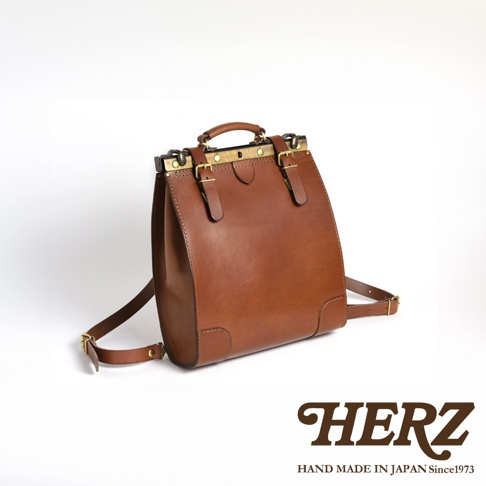 職人手作皮革復古口金後背包 P-7，以棕色皮革製成，設有金屬口金、皮帶扣和可調節的肩帶。