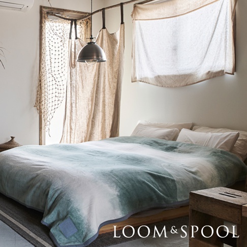 一條雙人短絨舒柔毯，以漸層的淺綠和白色調呈現，觸感柔軟，適合臥室使用。