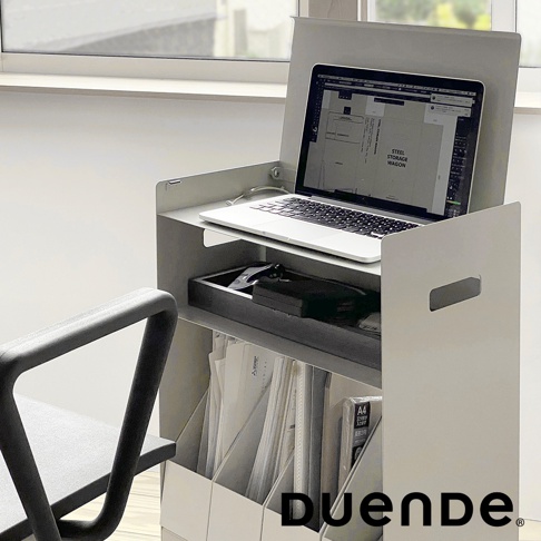 一臺淺灰色的多用途收納推車，上方擺放著一台打開的筆記型電腦，螢幕顯示著 STEEL STORAGE WAGON 的字樣，下方有一個黑色托盤，裡面放著電子產品，推車底部則收納著文件夾。