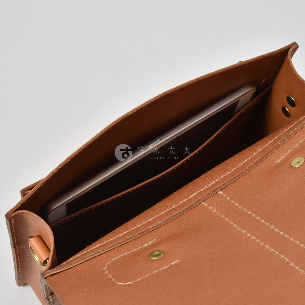 棕褐色皮革三用單扣商務後背包，內部有一個手機隔層，展示了包包的材質與結構細節。