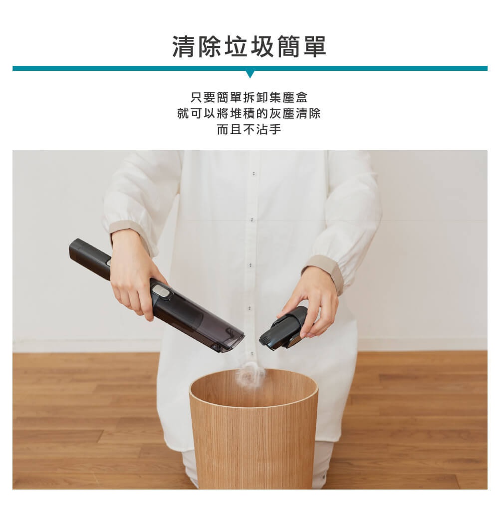 黑色攜帶式充電吸塵器，附有一個可拆卸的刷頭，正在清空集塵盒，灰塵倒入木紋垃圾桶中。