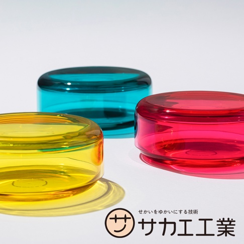 SAKAE 品牌下，藍綠色、紅色和黃色的三種顏色透明材質的蓋子點心碗，其中黃色碗的陰影清晰可見。