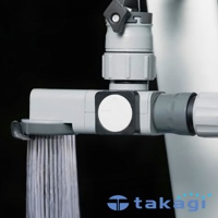 灰色塑膠製的水龍頭分支蓮蓬頭，帶有黑色旋鈕和圓形白色調節按鈕，蓮蓬頭下方有細密水流噴出。