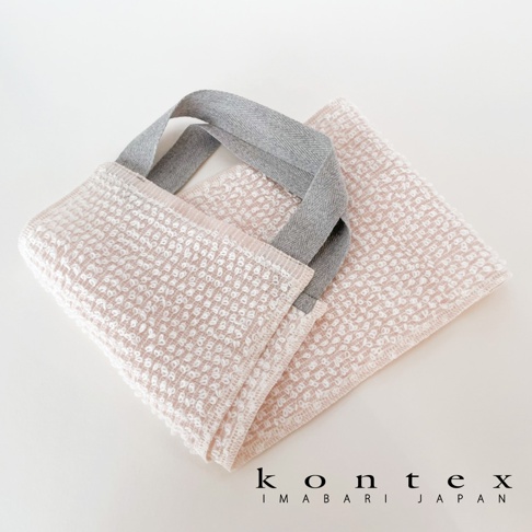 兩條柔軟的粉色棉質按摩洗澡巾，帶有灰色的織帶提把，表面有蜂窩狀紋理。