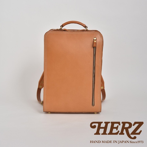職人手作皮革商務電腦後背包 R-25，展示為天然皮革原色，方形簡約設計，配有頂部提把、側邊拉鍊口袋及可調節式肩帶。