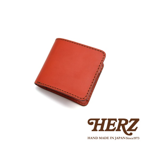 職人手作皮革經典雙折短夾，橘紅色，簡約設計，側邊縫線清晰。