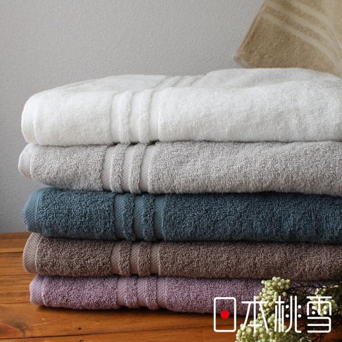 堆疊的今治飯店浴巾，從上至下顏色為白色、淺灰色、藍綠色、棕色、淺紫色，皆為柔軟的毛圈材質，帶有橫向條紋裝飾。