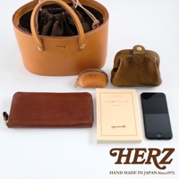 皮革束口手提包、咖啡色零錢包、棕色長夾、一本日文書籍及一支黑色手機，皆為皮革材質。