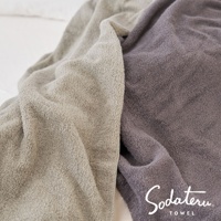 兩條柔順的雲感浴巾，一條為淺米色，另一條為煙灰色，材質蓬鬆，細緻的毛圈紋理清晰可見。