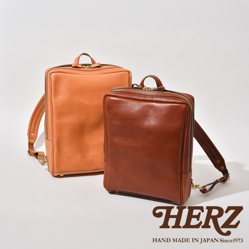 職人手作皮革軟皮商務後背包，分別為淺棕色和深棕色，質地光滑，設計簡潔。
