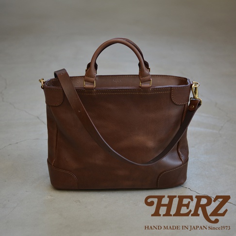 職人手作咖啡色皮革Organ兩用商務托特包，包身線條簡潔，配有雙提把及可拆卸肩帶，整體呈現自然復古質感。