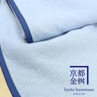 淺藍色絎縫紋理的兩用單人毯，邊緣飾有深藍色滾邊，右下角有京都金桝的品牌標誌。