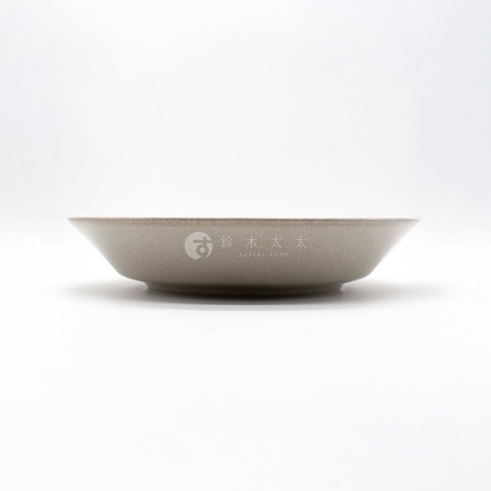 一個淺色調的義大利麵盤，盤面呈現自然的紋理，盤緣帶有細膩的顆粒感，盤底印有品牌標誌。