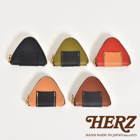 五款日本HERZ職人手作皮革零錢包，外觀呈現可愛的三角飯糰造型，並配有拉鍊開口與海苔般的黑色皮革細節設計，呈現出五種不同配色的精緻皮革質感。
