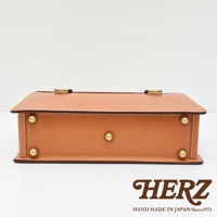 職人手作皮革機師箱 BC-31，淺棕色皮革，附有黃銅色金屬扣件和鉚釘，簡約方形設計，展現皮革質感。