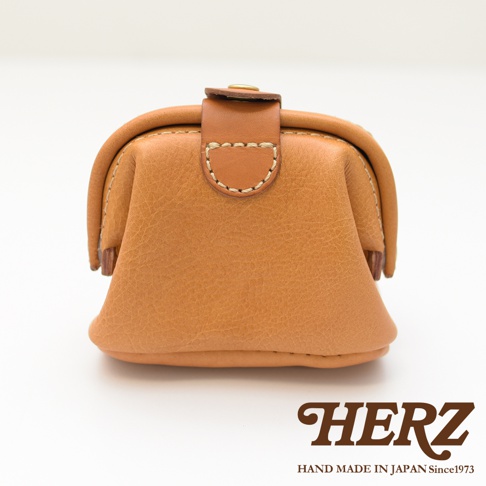 職人手作皮革口金化妝包 KF-143 M，採用天然皮革材質，呈現焦糖棕色調，設計簡約，帶有經典的口金開合與皮革裝飾細節。