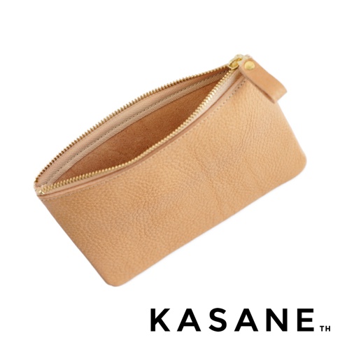 這是一個由北海道 KASANE 品牌推出的職人手作義大利 Vachetta Box 皮革收納包，呈現為淺棕色皮革材質，具有細緻的荔枝紋路，包口配備金色拉鍊與同材質皮革拉環，整體為簡約的梯形設計，背景為純白色。