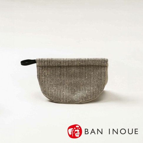 Tricot 棉麻防燙鍋套，織紋為米白色與細緻的灰色線條交織，底部呈半圓弧形，一側有黑色織帶提環。