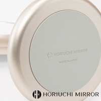 香檳金質感的圓形桌上鏡，鏡面為淺灰色，印有「HORIUCHI MIRROR」及「MADE IN JAPAN」字樣。