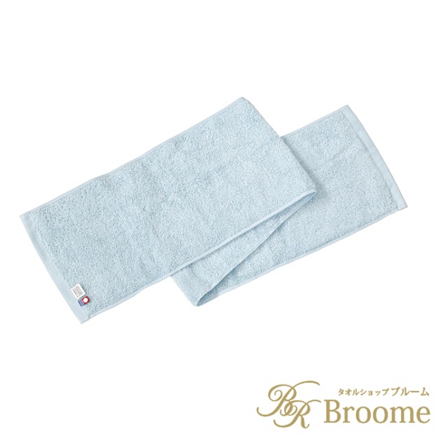 這是一款由 Broome 品牌推出的淺藍色長條形毛巾，表面呈現柔軟的毛圈織物質感，毛巾角落設有印有紅色圓點的今治毛巾品牌標籤，整體設計簡約實用。