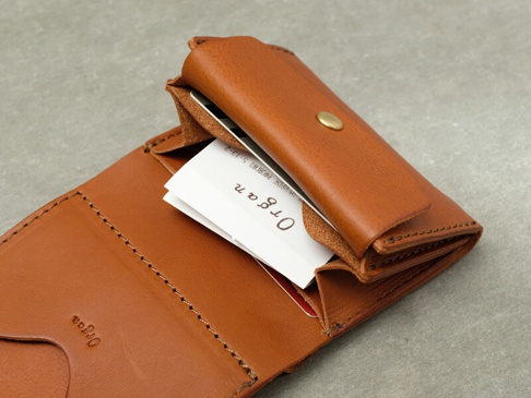 職人手作皮革Organ迷你短夾，卡其色，植鞣皮革材質，內部可見白色名片，短夾以黃銅釦固定，皮革表面有壓印「Organ」字樣，縫線精緻。