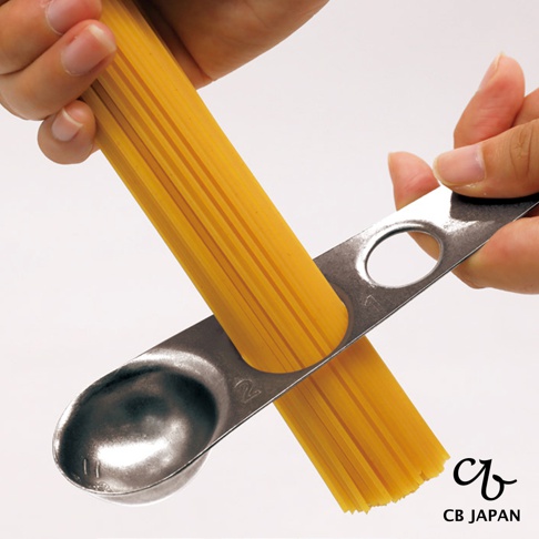 CB JAPAN 不鏽鋼義大利麵量匙，以兩根手指夾住一把不鏽鋼量匙，量匙上放著一把約兩份義大利麵的量，量匙上有2的刻度。