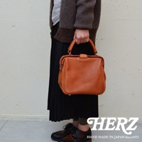 職人手作皮革Organ方形口金托特包，經典方形設計，採用鞣製皮革材質，搭配金色金屬扣環，呈現溫潤的焦糖棕色調，質感精緻，款式大方。