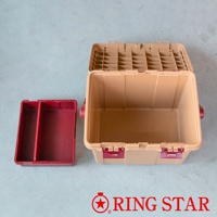 淺褐色塑膠儲物箱，帶有酒紅色提把和鎖扣，箱蓋內有網格分隔。旁邊有一個酒紅色的二格塑膠收納盒。