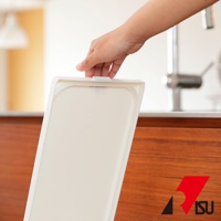 一只手正在開啟一個白色塑膠製的按壓式垃圾桶蓋。