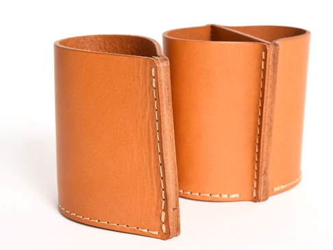 職人手作皮革筆筒 (KZ-89) S，採用天然鞣製皮革製成，呈現溫潤的焦糖棕色。筆筒為圓柱形，內部分為兩格，側邊以白色縫線手工車縫，質感細緻，設計簡約實用。