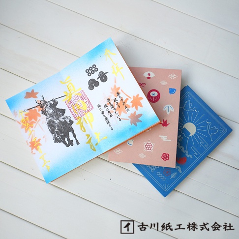 三本美濃和紙御朱印帳，分別為藍色、粉色和淺藍色，上面印有武士騎馬、達摩、龜、楓葉、鳥與太陽等圖案。