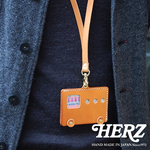 日本HERZ手工皮革製作的棕色巴士造型交通卡套，掛繩為淺棕色，上面印有日文。