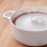 白色食品級矽膠鍋蓋，設計成貓咪造型，有可愛的耳朵和鼻子，用於烹飪或微波爐加熱，附有鍋柄。