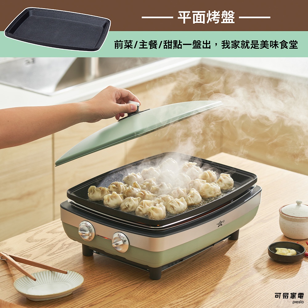 一個綠色和銀色的烤盤，上面有許多蒸氣，正在烹飪著一盤水餃。烤盤上方有一隻手正準備蓋上綠色的鍋蓋。