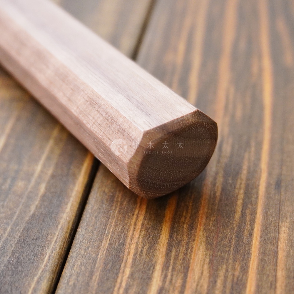 [景清] Chromax鋼水果刀的胡桃木刀柄，呈現自然木紋與多邊形切面，置於深色木紋背景上。