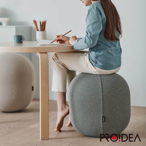 MALLOW Knit 收納彈力平衡球-迷你款，織物材質，灰色。一個女孩坐在上面，雙腳懸空。