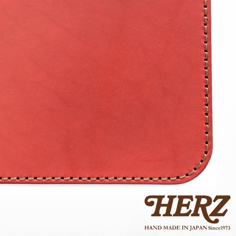 厚實的紅色皮革，有精細的縫線，展現職人手作質感。