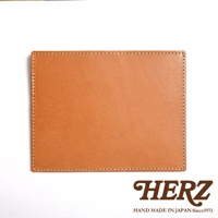 淺棕色皮革輕便記事本書套，邊緣以白色縫線裝飾，簡約設計。