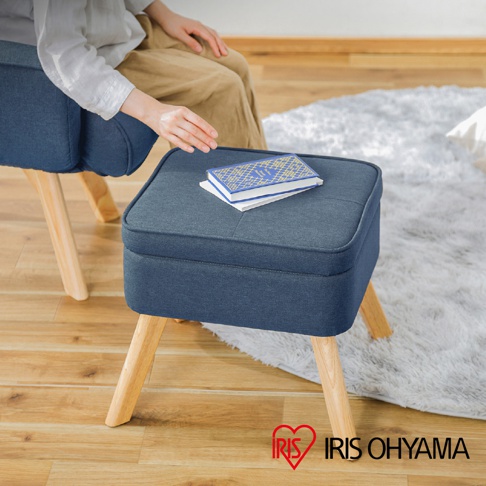 藍色布藝北歐風收納椅凳，方形座面，附有兩本書籍，腳架為淺木色，整體簡潔實用。