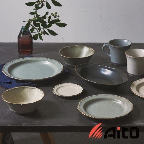 Aito Stitch 系列金彩浮雕復古湯碗，搭配同系列盤、杯及醬料碟，擺設在深色桌面，左側有裝有綠葉植物的玻璃瓶。