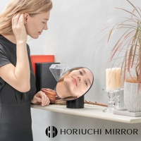 NAPURE 桌上型可調節化妝圓鏡，黑色底座，鏡面反射出一位女性的臉部，背景有裝飾物和植物。