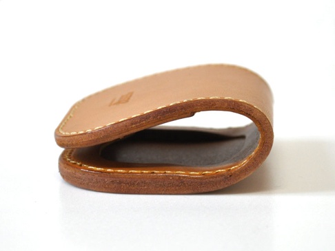 職人手作皮革馬蹄造型零錢包，採用淺棕色皮革製成，手工縫線清晰可見，展現獨特馬蹄造型設計。