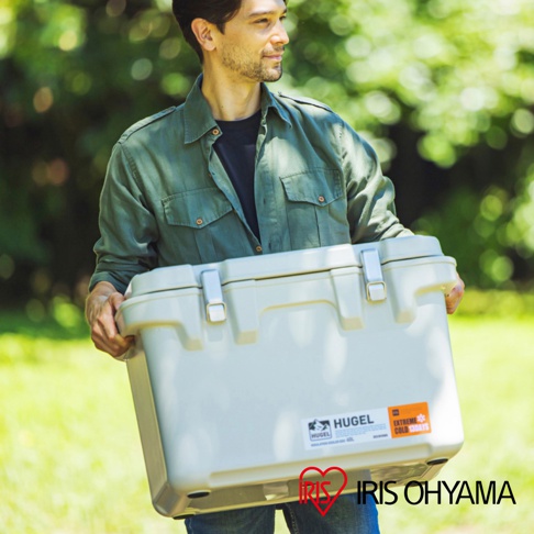 一名男子正抱著一個米白色、容量40公升的HUGEL真空隔熱冰桶，冰桶有兩個金屬扣，側面貼有品牌標籤。