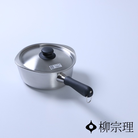 柳宗理不鏽鋼霧面單手鍋，鍋身呈現溫潤的霧面金屬質感，配有黑色握柄及圓形鍋蓋，鍋緣兩側具備獨特的導流口設計，右下角印有柳宗理品牌名稱與標誌。