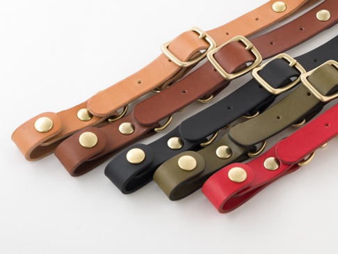 多種顏色（淺棕、棕、黑、軍綠、紅）的職人手作皮革背包用減壓胸前扣帶，均配有黃銅色釦環和金屬釦。