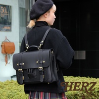 黑色皮革三用學生包，配有金色金屬扣和可拆卸肩帶，可作背包、側背包或手提包使用。