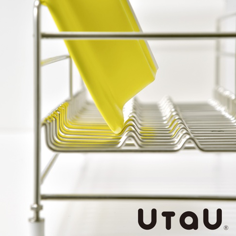 不鏽鋼窄型碗碟瀝水架，附有可拆卸瀝水盤，展示架上放置著一個亮黃色的盤子，整體為簡潔的銀色不鏽鋼材質。