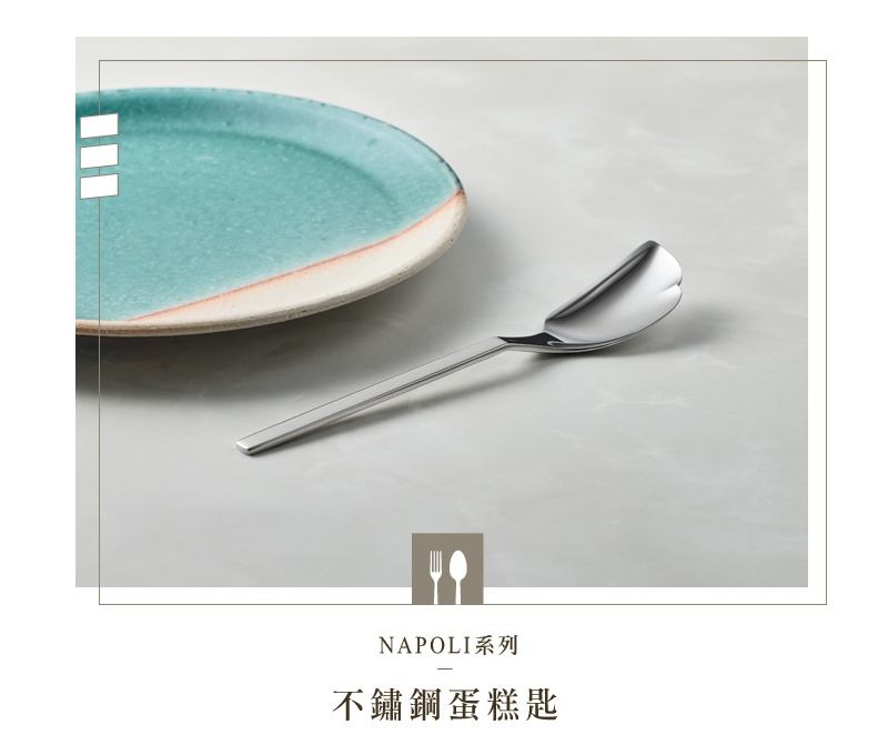 NAPOLI系列不鏽鋼蛋糕匙，特寫鏡頭展示了蛋糕匙的側面，其不鏽鋼材質呈現光滑的銀色光澤。蛋糕匙的勺部設計獨特，邊緣帶有細微的弧度，暗示其專為蛋糕設計。背景是一個帶有藍綠色釉面和米白色邊緣的圓盤，盤子的一角被截斷，增添了畫面的藝術感。整體構圖簡潔優雅，突顯了餐具的精緻細節。