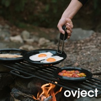 黑色琺瑯煎鍋組，包含一個煎鍋，鍋內有兩個太陽蛋，另有兩個鍋子分別裝有烤過的番茄和薄餅，置於營火上的烤架上，由手持鍋柄。