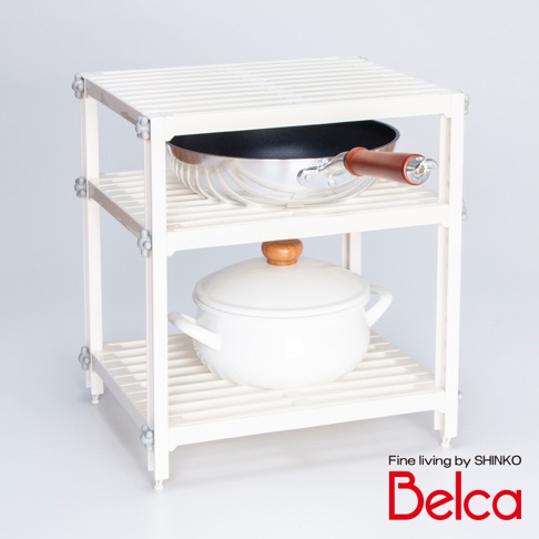 白色三層收納架，架體為塑膠材質，每層架面為條紋設計。頂層放置一個不鏽鋼平底鍋，鍋柄為木質。中層放置一個白色帶木質鍋蓋的湯鍋。